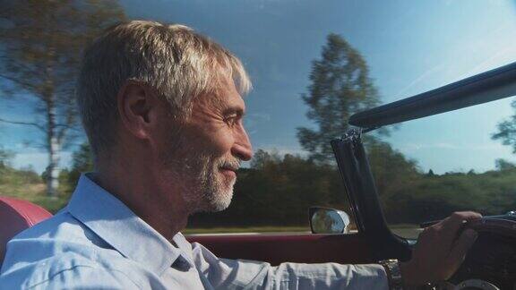 一个在阳光明媚的日子开着老爷车的快乐男人