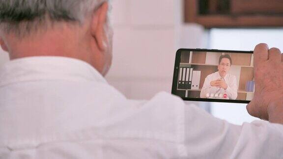 亚洲老人在家视频会议远程视频电话亚洲商人在家远程工作交流社会电话会议