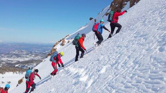 高山高山登山队冬季在高海拔山峰上排成一行行走