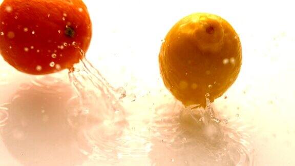 橙色和柠檬落在白色潮湿的表面上弹跳