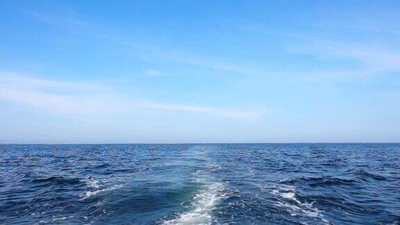 在平静的海面和晴朗的天空下慢动作的游船轨迹