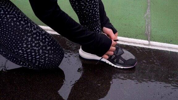 女人系鞋带的特写准备慢跑的女性运动健身运动员