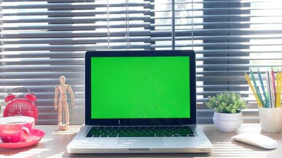 相机镜头拉近笔记本电脑与空绿色屏幕产品显示蒙太奇在桌子上电影模拟绮年华