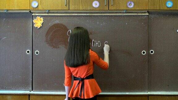女孩用粉笔在黑板上写字