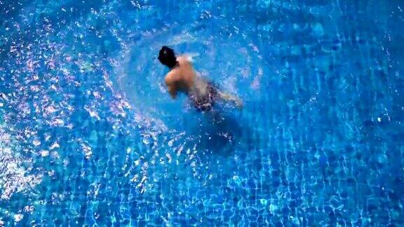 SLOMO-俯视图亚洲人试图做后空翻进入游泳池