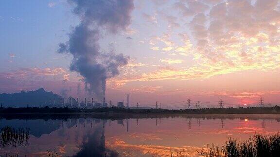 有日出和冒烟的煤的发电厂