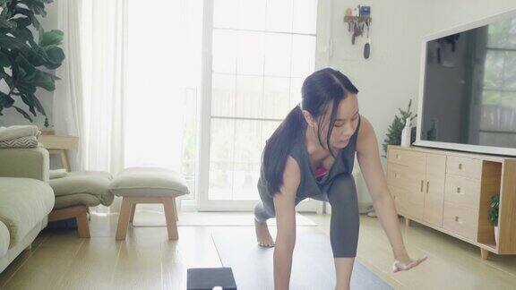 在家里用笔记本练瑜伽的女人