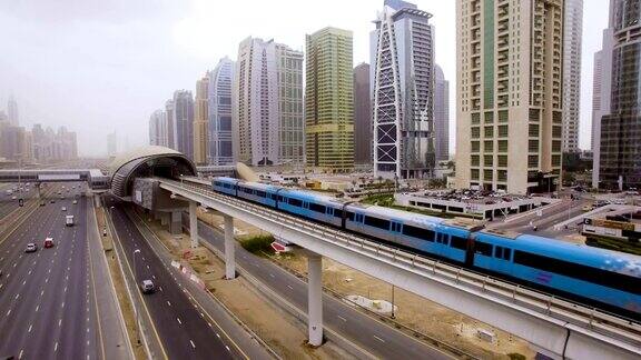 火车在阿联酋迪拜摩天大楼之间的高速公路上越过高架桥