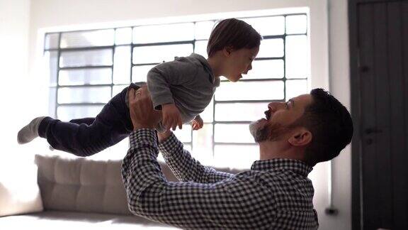 快乐的父亲和有特殊需要的儿子在家里玩耍