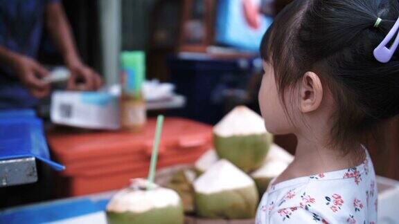 小女孩在街头买椰子