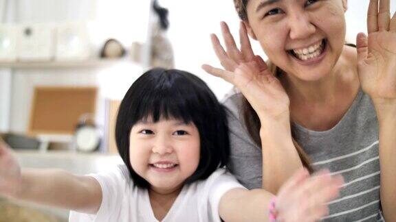 快乐的亚洲小女孩和妈妈一起玩peekaboo