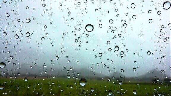 雨点落在车窗在山的背景