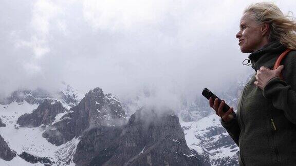 一名女徒步旅行者在悬崖边停下来观看前方的景象