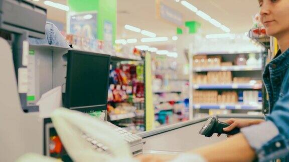 收银员扫描商店里的商品漂亮的女孩在超市买菜