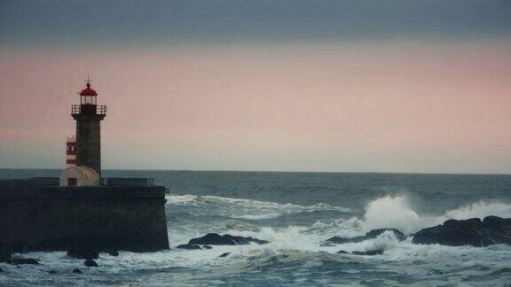 巨浪冲击着码头岸边的灯塔
