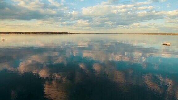 蓝天和白云倒映在寂静的河水里日落天空之上的水景水面上的涟漪