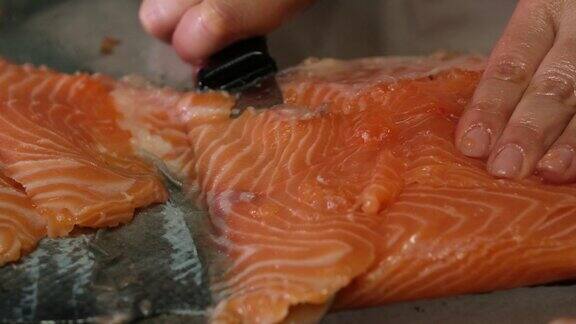 用刀切下大片的鲑鱼烹饪寿司的慢动作视频