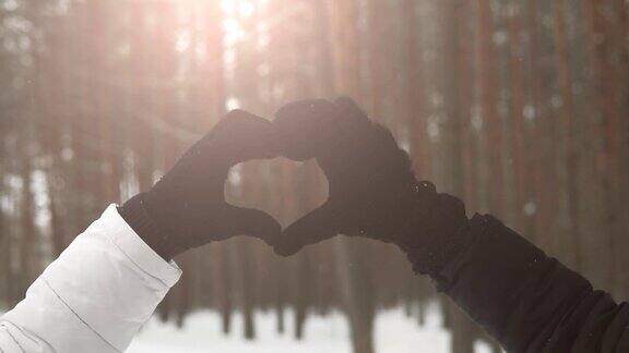在冬天的公园里一对相爱的情侣用手指交心