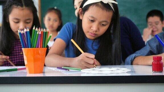 亚洲女教师教混血儿在教室里看书幼儿园的学前概念