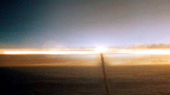 在日落时穿过云层发射到太空的火箭
