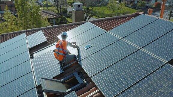 技术员安装和维护安装在家庭屋顶的太阳能光伏板
