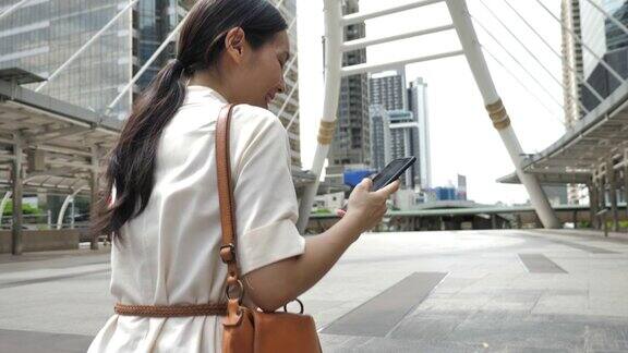 亚洲女商人在城市使用智能手机