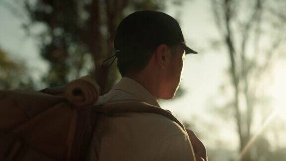 男子在假日里背着背包在树林里徒步旅行