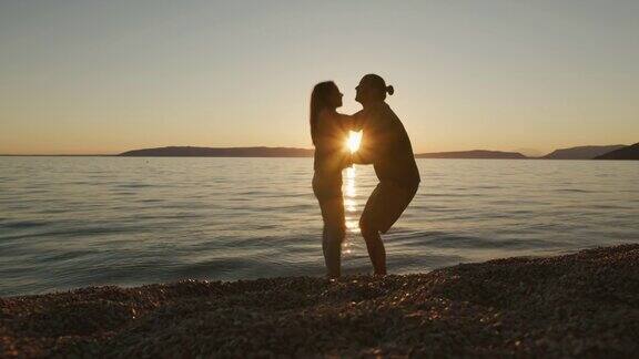 年轻夫妇在海滩上拥抱浪漫