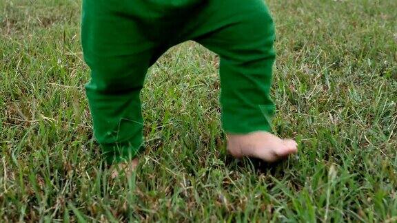 亚洲小男孩在公园的绿草地上散步