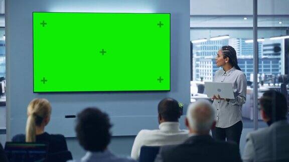 现代产品展示活动:黑人女商人发言使用绿色色度键屏幕墙电视不同投资者数字企业家商人的新闻发布会