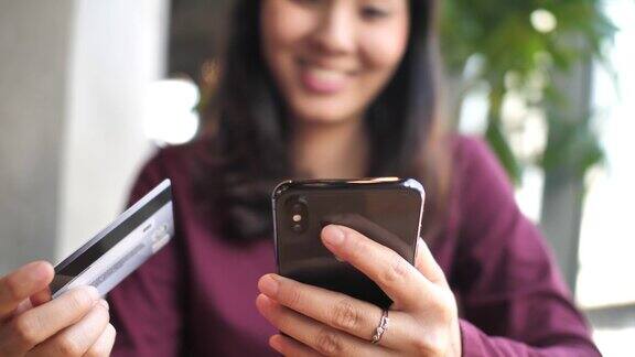 一个女人正在用信用卡在智能手机上网上购物
