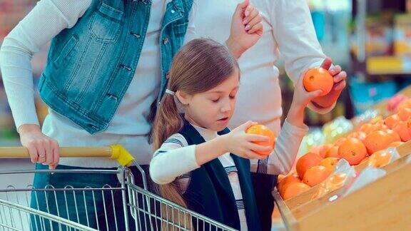小女孩在果蔬超市选购橘子