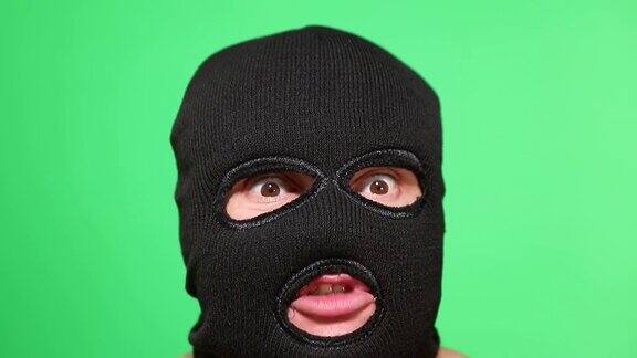 可怕的小偷或强盗戴着面具看着摄像机