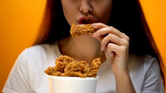 女孩吃鸡翅高热量食物和健康风险胆固醇