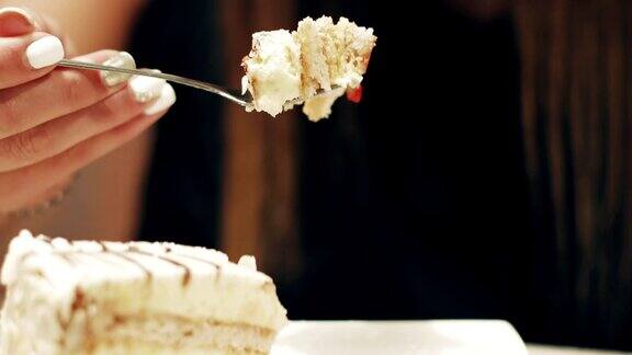 迷人的黑发女子在咖啡厅吃一块蛋糕