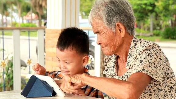 奶奶和孙子在用平板电脑