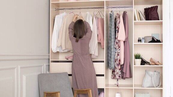 穿衣服的女人在衣柜的架子上挑选衣服寻找穿什么
