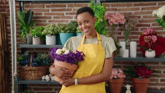 非裔美国妇女花商在花店拿着植物