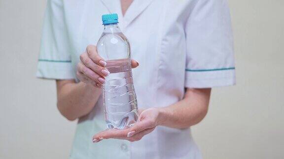 女性营养学家或营养师医生健康生活方式概念-手持一瓶水