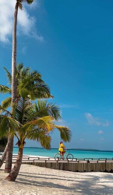 金发女子骑自行车在木材码头在马尔代夫热带岛屿