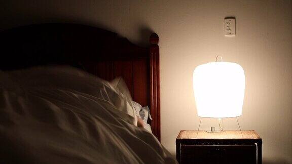 年轻人躺在床上关掉床头柜里的灯一个人躺着睡觉的时候在想一些事情