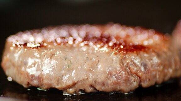 在煎锅里用油煎着的汉堡肉