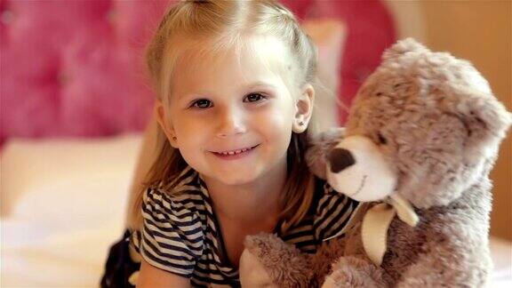 可爱的小女孩抱着她的小熊