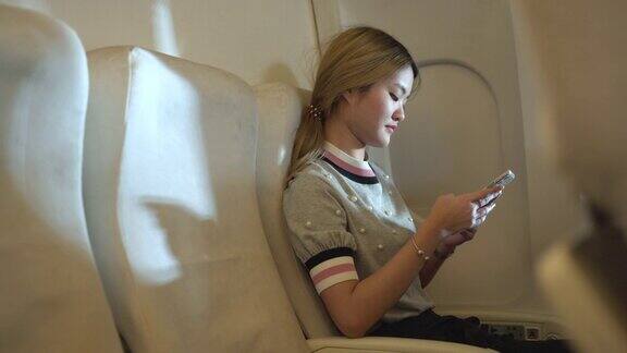 年轻女子在飞机上使用手机