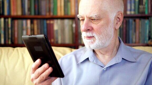 老人在家里放松阅读电子书享受退休生活书架在后台
