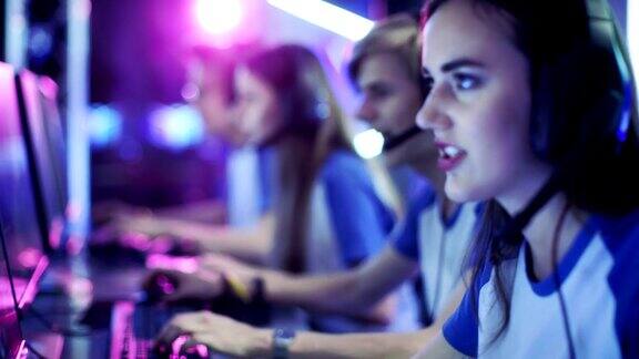 在一场网络游戏锦标赛上玩电子游戏的职业电竞玩家团队他们对着麦克风交谈竞技场用霓虹灯看起来很酷