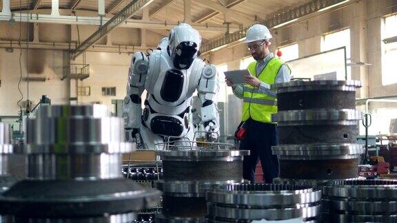 机器人正在工人的监督下重新安置金属零件