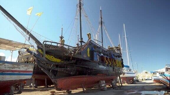 一艘海盗船正在修复中一艘旧的黑船停在陆地上
