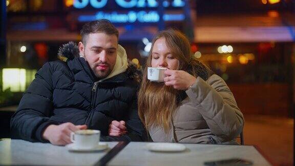 冬天的夜晚城市里飘着雪一对年轻的情侣在咖啡馆里约会