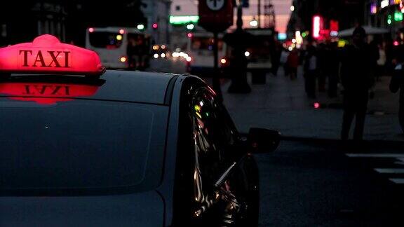 黑色轿车与红色背光出租车在晚上站在街上